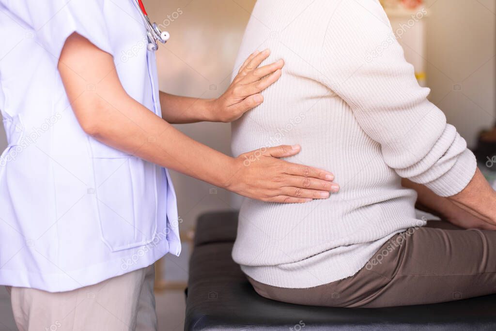 Physiotherapist doing treatment to senior woman patient in clinic ,Elderly women suffering from low-back lumbar pain,Physical therapy concept