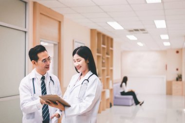 Asyalı doktor hastaların tedavisi için hastanede çalışıyor ve tartışıyorlar.