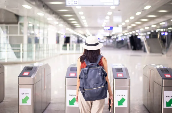 電車の駅で自動ドアの入り口に歩いて女性旅行者 旅行保険のコンセプト — ストック写真