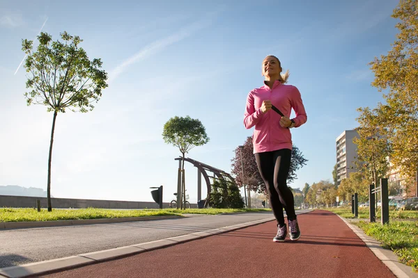 Chica corriendo en la carretera en la ciudad — Foto de Stock