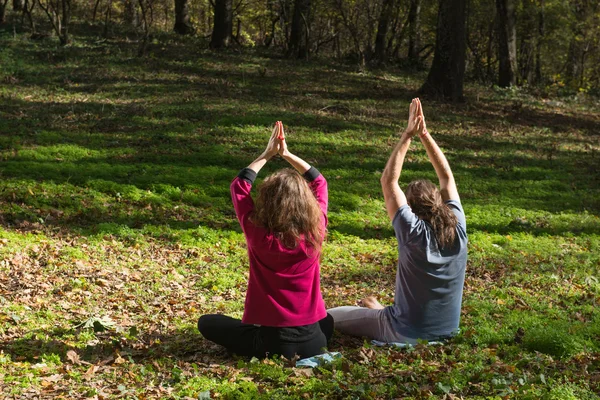 Meisje en man doen yoga meditatie — Stockfoto