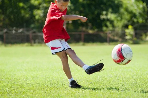 Boy kicking football — Stock Photo, Image