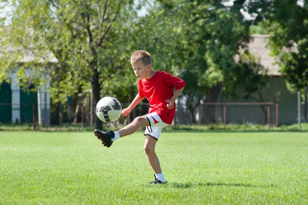 Pojken sparkar fotboll — Stockfoto