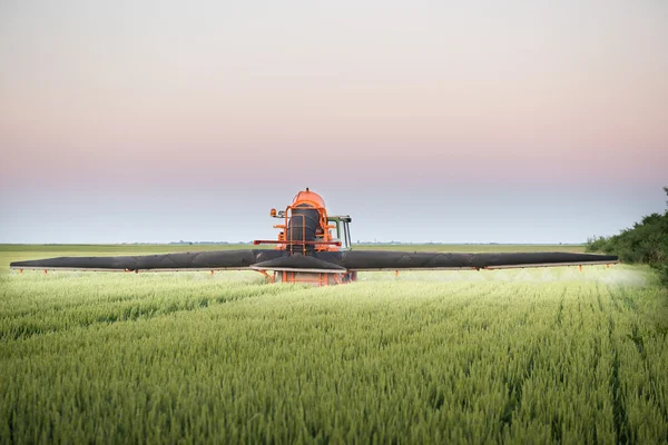 Распыление трактора на поле — стоковое фото