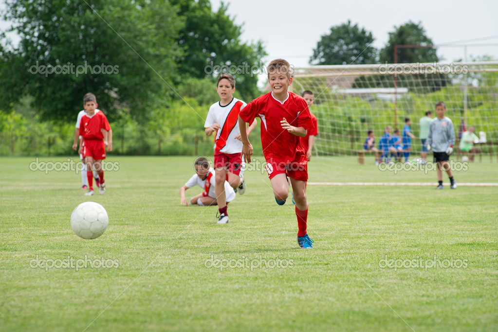 Boys kicking football Stock Photo by ©fotokostic 26227413