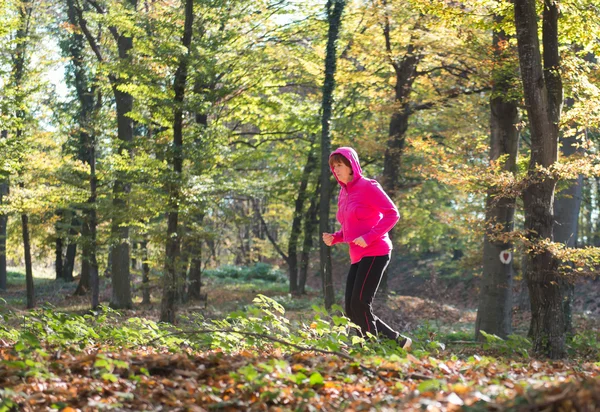 Frau läuft im Wald — Stockfoto