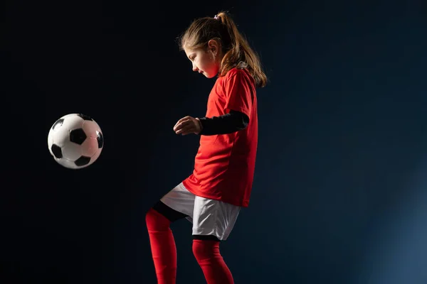 女の子はサッカー場でサッカーボールを蹴り — ストック写真