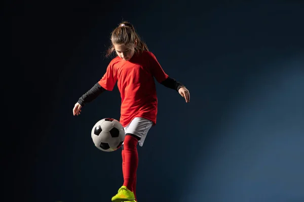 女の子はサッカーボールで遊ぶ 青の上に孤立立って — ストック写真