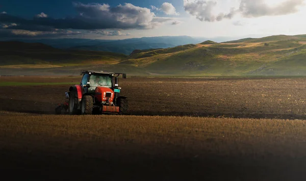 トラクターは夕暮れ時に畑を耕し — ストック写真