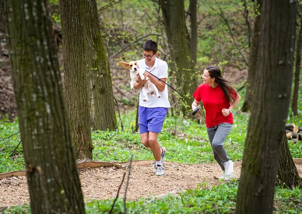 Junges Glückliches Paar Läuft Mit Hund Durch Park — Stockfoto