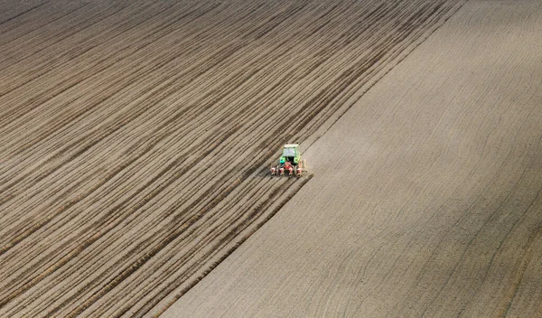 Traktör tohumu olan çiftçi - ilkbaharda tarım tarlalarına ekin ekiyor.