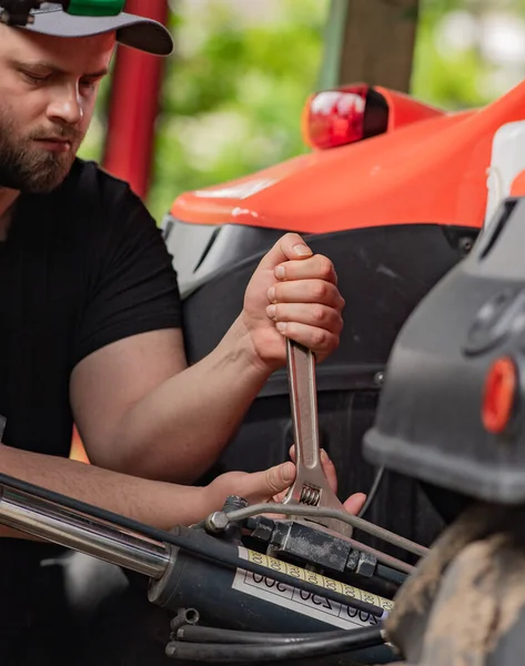 Çiftçi tarladaki tarım makinelerini tamir ediyor. 