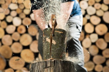 Hand and axe in firewood, chopping wood for fire heat 