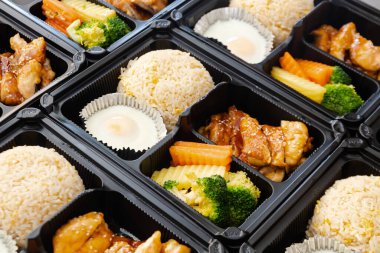 Modern Asya pirinç kutusu, Japon bento kutusu, plastik paketlerde Japon yemek kutuları yemeye hazır. Teriyaki tavuklu kızarmış pilav..