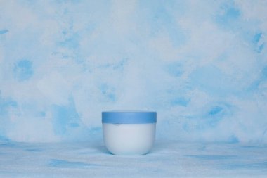 Saf beyaz, plastik, konteynır. Kozmetik, krem, saç maskesi, tıbbi ve güzellik ürünleri için ambalaj, şişe şablonu. Beyaz-mavi arkaplan.