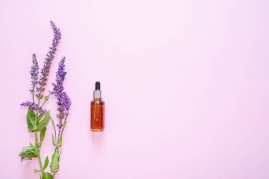 Flat lay composition with lavender flowers and natural cosmetics on a pink background. View from above