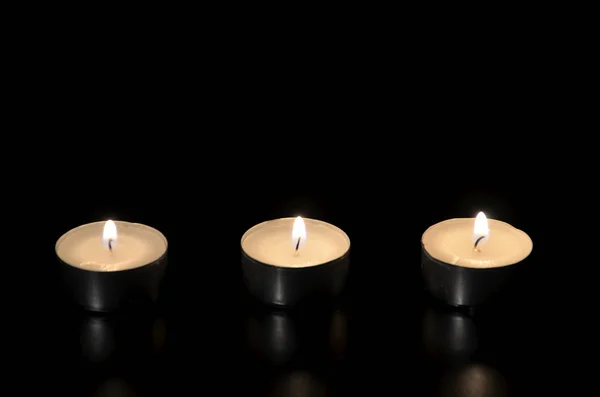 Luz das velas acesas no escuro — Fotografia de Stock
