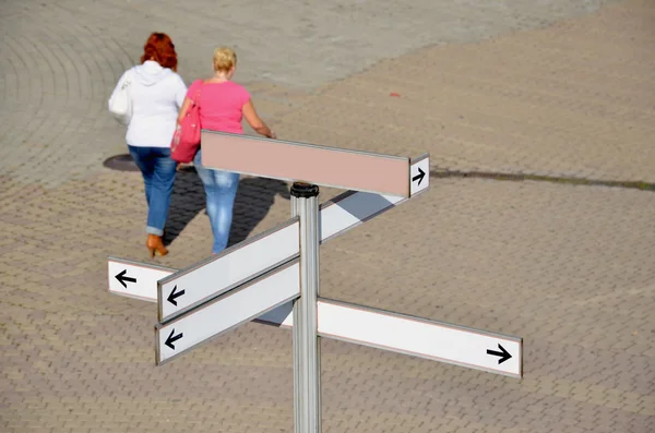 Segnavia chiaro e due donne sulla piazza del paese — Foto Stock