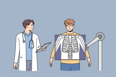Doktor, erkek hastayı röntgende muayene ediyor.