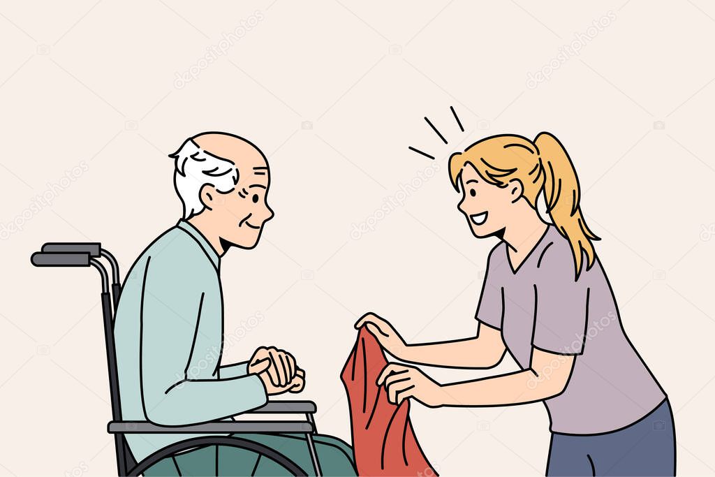 Attentive caregiver take care of mature patient in wheelchair