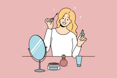 Gülümseyen kız masasına oturmuş makyaj yapıyor ve rimel sürüyordu. Mutlu genç kadın aynaya bak güzellik ürünleri uygula. Günlük rutin ve hazırlık. Kozmetoloji. Vektör illüstrasyonu. 