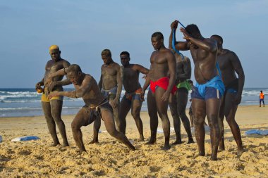 Dakar. Senegal. 13 Ekim 2021. Bir grup Senegalli güreşçi Laamb kumlu deniz kıyısında dövüşten önce rakibinin gücünü göstermek için ritüel dansı yapıyor..