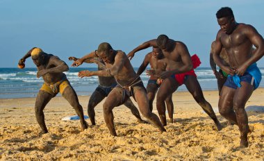 Dakar. Senegal. 13 Ekim 2021. Bir grup Senegalli güreşçi Laamb kumlu deniz kıyısında dövüşten önce rakibinin gücünü göstermek için ritüel dansı yapıyor..