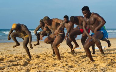 Dakar. Senegal. 13 Ekim 2021. Bir grup Senegalli güreşçi Laamb kumlu deniz kıyısında dövüşten önce rakibinin gücünü göstermek için ritüel dansı yapıyor..