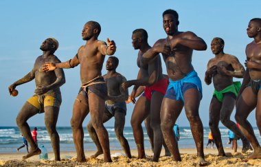 Dakar. Senegal. 13 Ekim 2021. Bir grup Senegalli güreşçi Laamb kumlu deniz kıyısında dövüşten önce rakibinin gücünü göstermek için ritüel dansı yapıyor..
