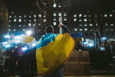 Hükümetler, Londra, 124; İngiltere - 2022.02.25: Ukrayna 'daki savaşı durdurmak için Rusya' ya İngiliz Hükümeti, AB ve ABD 'den daha sert yaptırımlar uygulanmasını talep eden Ukrayna bayrağı taşıyan adam
