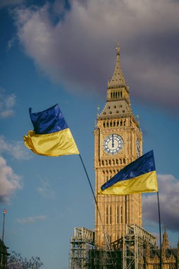 Parlamento Meydanı, Londra -124; İngiltere - 2022.03.06: Savaş karşıtı protestoda Big Ben parlamento binası önünde Ukrayna bayrakları