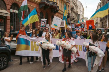 Budapeşte (124; Macaristan - 2022,03.08): Budapeşte 'de bayraklı insanlar Ukraynalıları desteklemek ve Rusya' nın başlattığı savaşı durdurmak için toplandılar