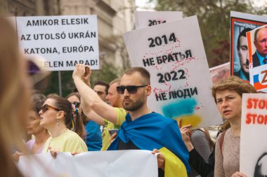 Budapeşte (124; Macaristan - 2022,03.08): Budapeşte 'de bayraklı insanlar Ukraynalıları desteklemek ve Rusya' nın başlattığı savaşı durdurmak için toplandılar