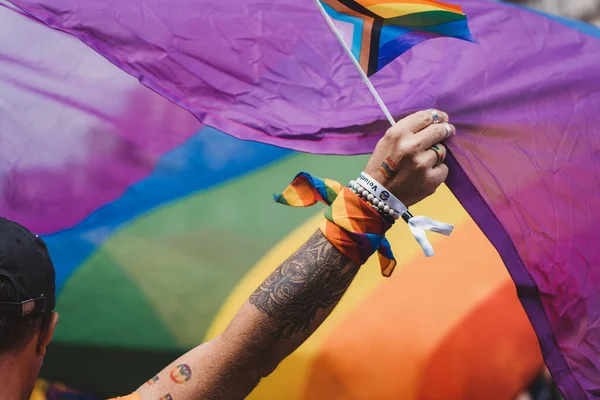 Londra / İngiltere - 02 / 07 / 2022: Londra LGBTQ Onur Yürüyüşünü kutlayan dev gökkuşağı bayrağına sahip insanlar
