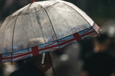 Londra (124; İngiltere - 2022.09.08) Kraliçe Elizabeth 'in ölümünden sonra Buckingham Sarayı' nın dışındaki yağmurun altında insanlar yas tutuyor ve çiçekler getiriyorlar.