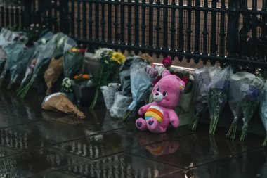 Londra (124; İngiltere - 2022.09.08) Kraliçe Elizabeth 'in ölümünden sonra Buckingham Sarayı' nın dışındaki yağmurun altında insanlar yas tutuyor ve çiçekler getiriyorlar.