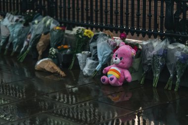 Londra (124; İngiltere - 2022.09.08) Kraliçe Elizabeth 'in ölümünden sonra Buckingham Sarayı' nın dışındaki yağmurun altında insanlar yas tutuyor ve çiçekler getiriyorlar.