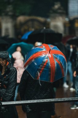 Londra (124; İngiltere - 2022.09.08) Kraliçe Elizabeth 'in ölümünden sonra Buckingham Sarayı' nın dışındaki yağmurun altında insanlar yas tutuyor ve çiçekler getiriyorlar.