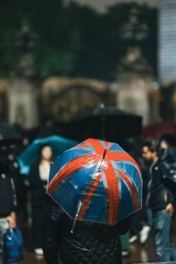 Londra (124; İngiltere - 2022.09.08) Kraliçe Elizabeth 'in ölümünden sonra Buckingham Sarayı' nın dışındaki yağmurun altında insanlar yas tutuyor ve çiçekler getiriyorlar.