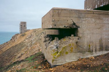 Jersey Adası, Kanal 124; İngiltere - 2022.01.29: Bulutlu bir günde adanın kayalıklarında terk edilmiş 2. Dünya Savaşı sığınağı