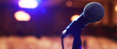 Konser salonunda ya da konferans odasında sahne ışıklarında mikrofonu kapat. Uzay afişini kopyala. yumuşak odak.