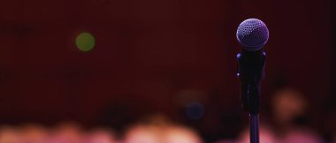 Konser salonunda ya da konferans odasında sahne ışıklarında mikrofonu kapat. Uzay afişini kopyala. yumuşak odak.