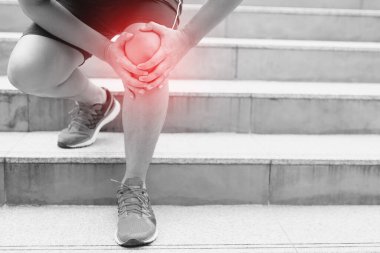 Koşucu acı verici bir şekilde burkulmuş ya da kırılmış. Atletizm eğitimi, merdivenlerden inip çıkarken kaza. Spor burkulması diz sakatlığına neden olur. Ve bacak kemikleri ile ağrı.  