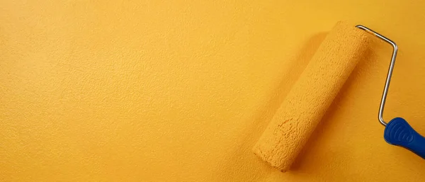 辊刷油漆 工人油漆表面墙面油漆公寓 装修与黄色油漆 在空白处空白处写下描述性文字 — 图库照片