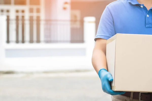 parcel delivery man wear protective gloves blue, protect Hygiene germs and bacteria of a package through a service send to home.  hand holding consign and submission customer accepting a of box.