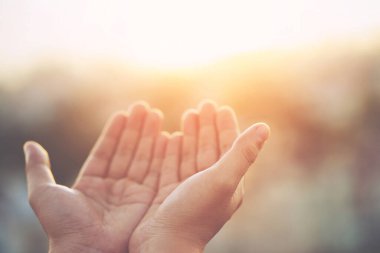 İnsan elleri avuçlarını açıp Tanrı 'ya inanç ve inançla gökyüzüne dua eder. Din ve maneviyatı umut, sevgi ve bağlılığın gücüne inanarak kavra. doldurucu ton klasiği.