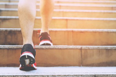 Modern şehirde merdivenlerden çıkan, yakın plan çalışan bir adam. Ofiste aceleyle çalışmak için yoğun bir saatte. İşteki ilk sabah boyunca. Merdiven boşluğu. yumuşak odak.