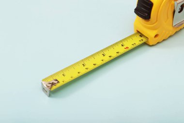 Duvarcı için sarı mezura mavi arka plana yerleştirildi. Yumuşak odak.