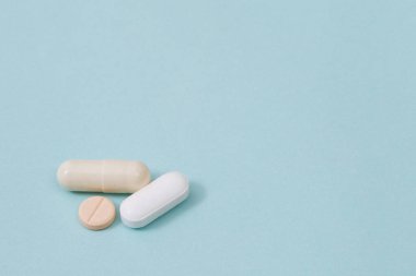 Makro hapların dağıtılması engellendi. Yüzey tabletlerine beyaz arka planda renkli haplar konuyor. İlaç tıbbi sağlık konsepti.