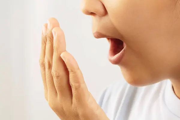 Women have bad breath caused by swollen gums.
